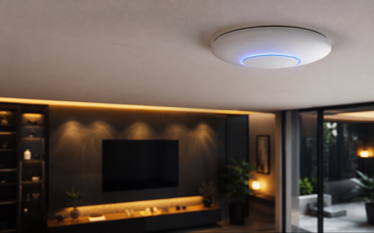 Discreet white ceiling-mounted wireless access point providing seamless Wi-Fi coverage in an elegant modern living room